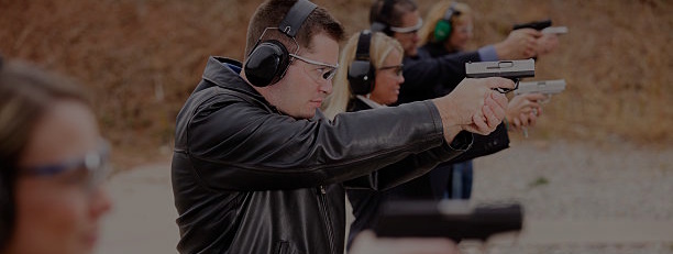 A group of people practicing at the gun range. Photographed on location at a shooting range.