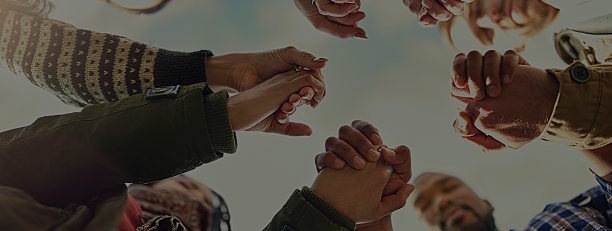Shot of a group of friends putting their hands together in prayer